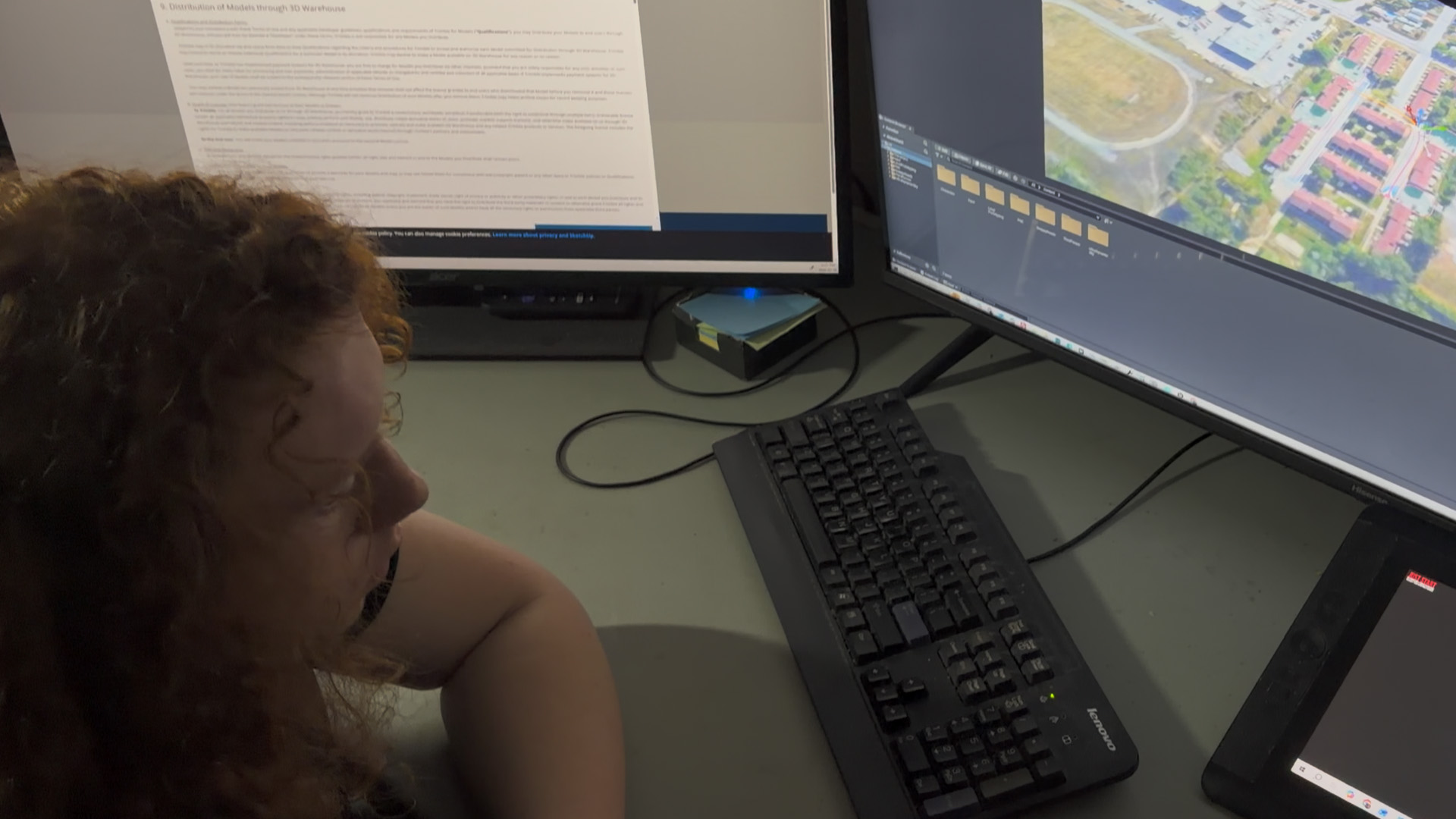 A young developer working with 3D city assets at a computer